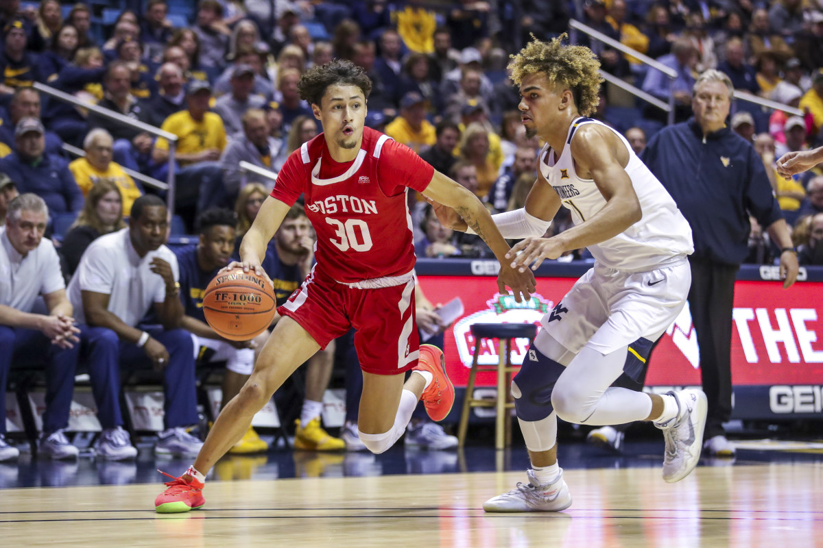 Boston University Terriers guard Javante McCoy (30) drives past West Virginia Mountaineers forward Emmitt Matthews Jr. (11) during the first half at WVU Coliseum.